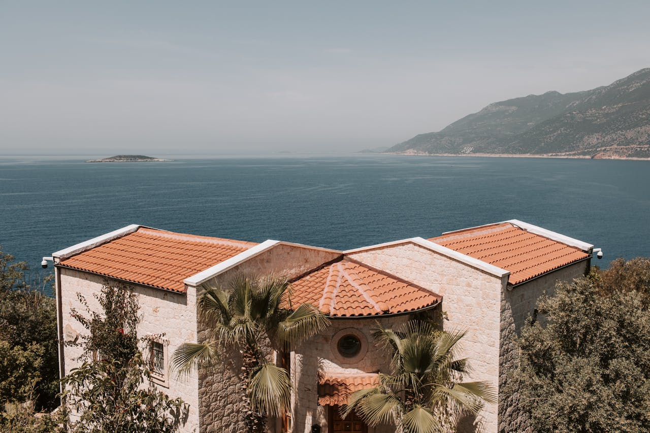 our-journey-03 Scenic view of a Mediterranean villa with orange roofs overlooking the Antalya coastline.