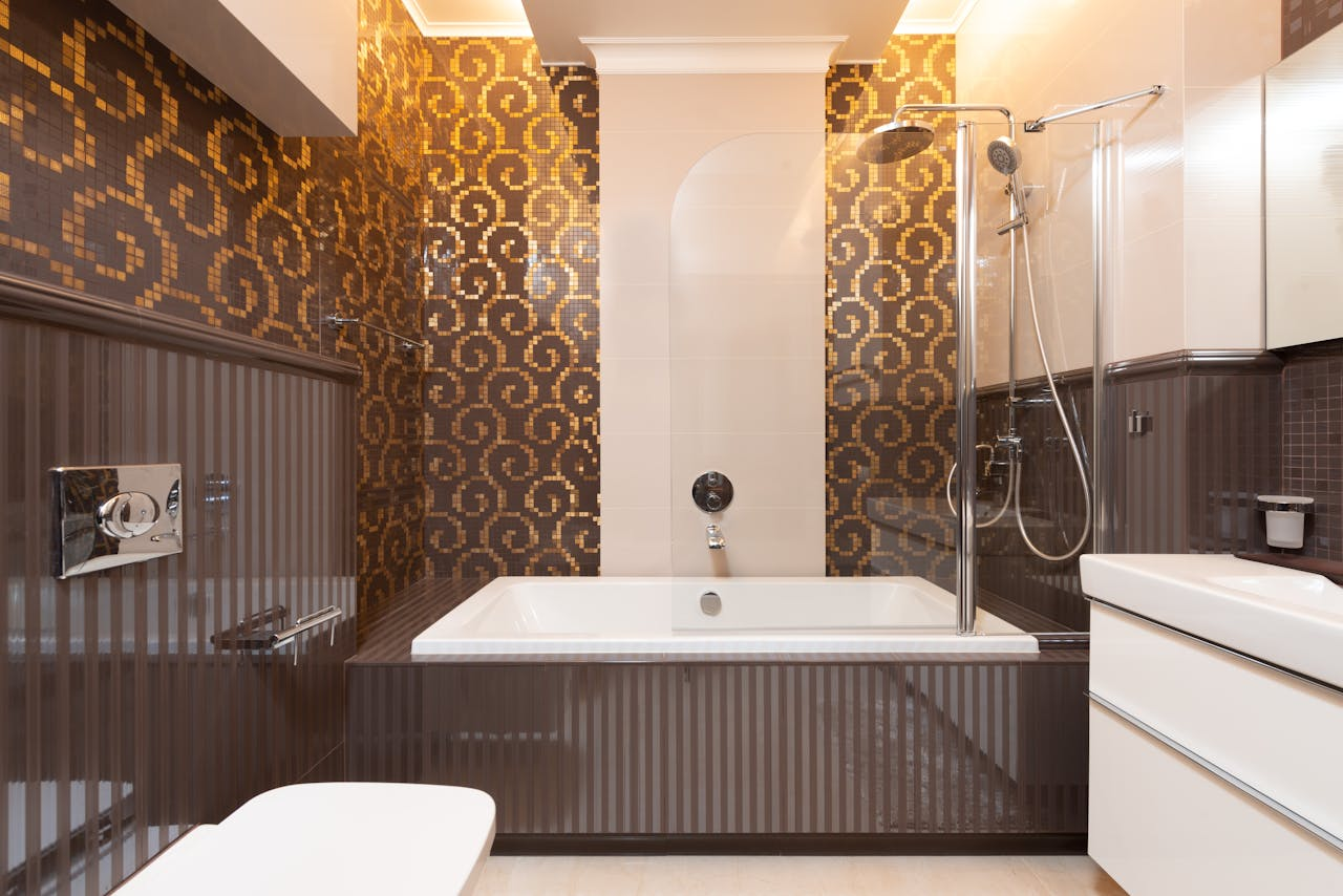 who-we-are-img Elegant bathroom featuring a bathtub and mosaic-tiled walls in a contemporary design.